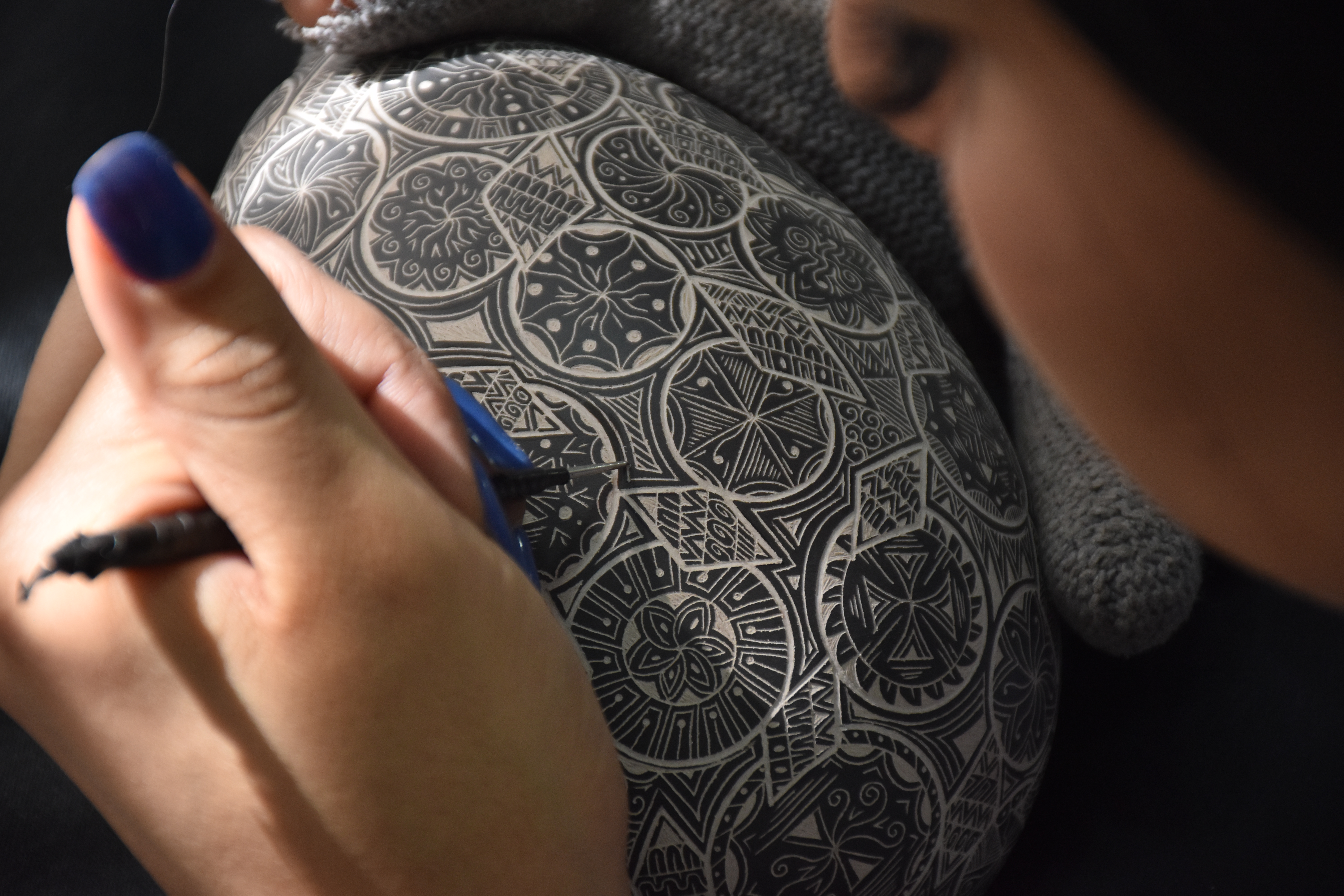 Detalle de grabado artesanal sobre barro negro realizado por artesana en Chihuahua