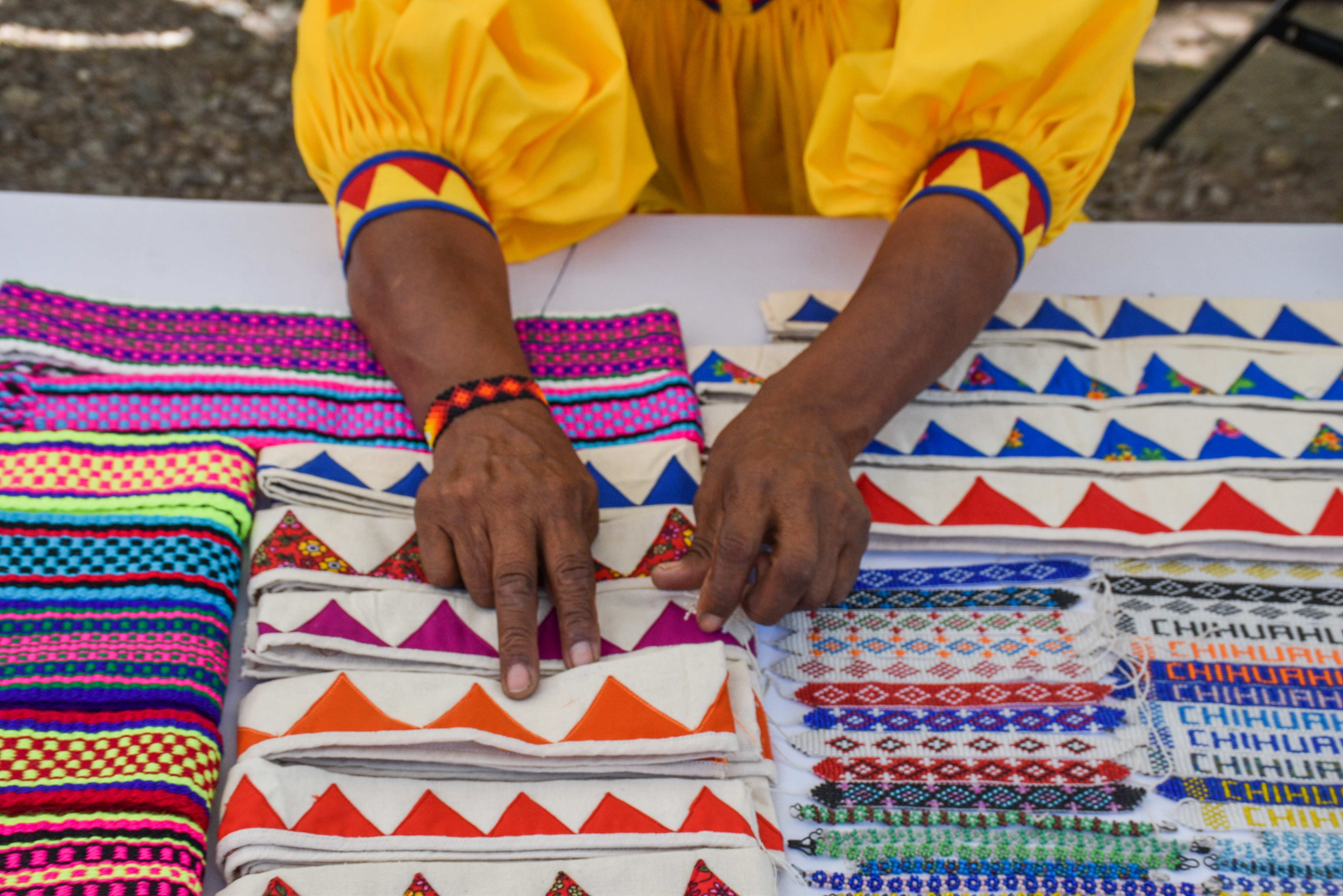 Textiles artesanales rarámuri bordados a mano en Chihuahua, con patrones coloridos y pulseras tradicionales